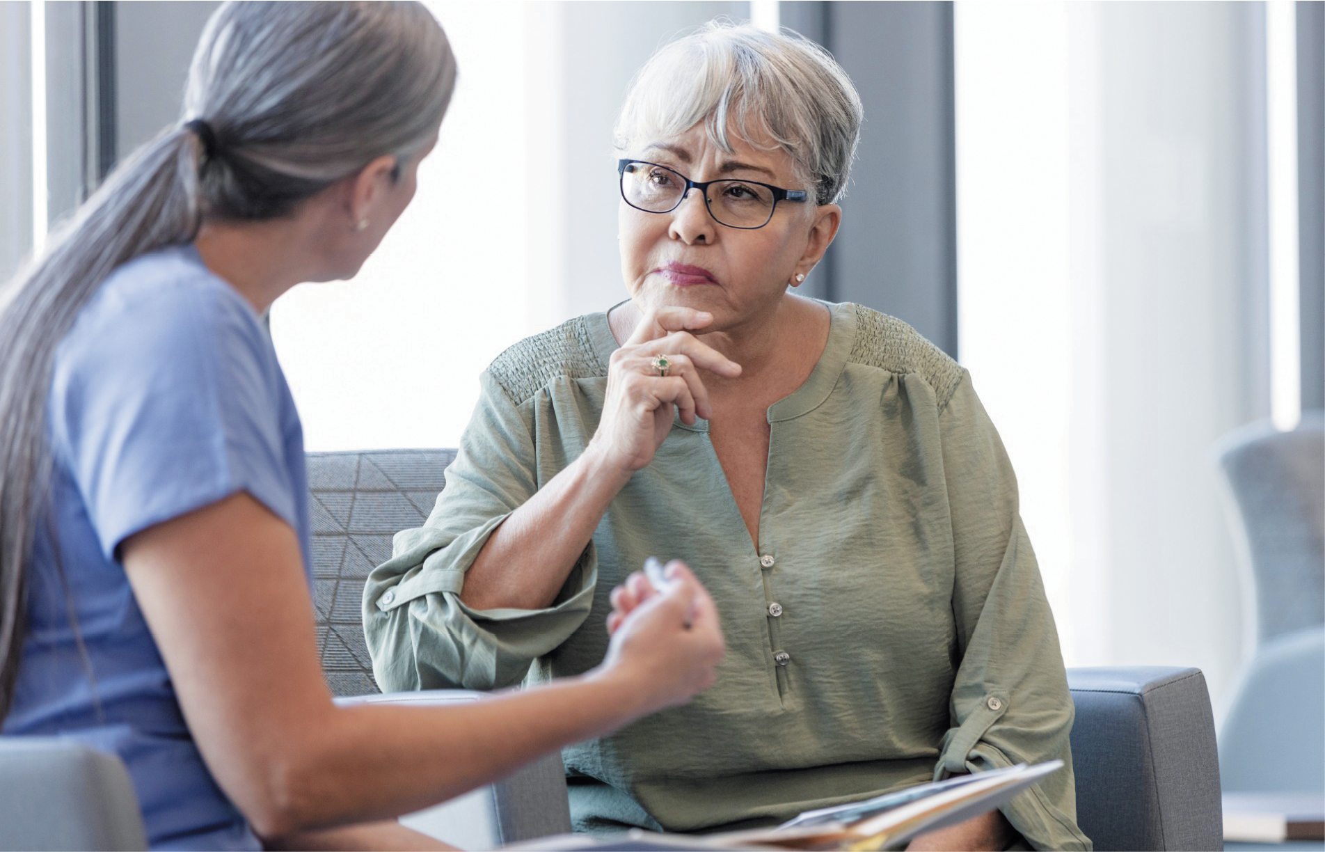 Older female patient looking thoughtfully at her doctor.