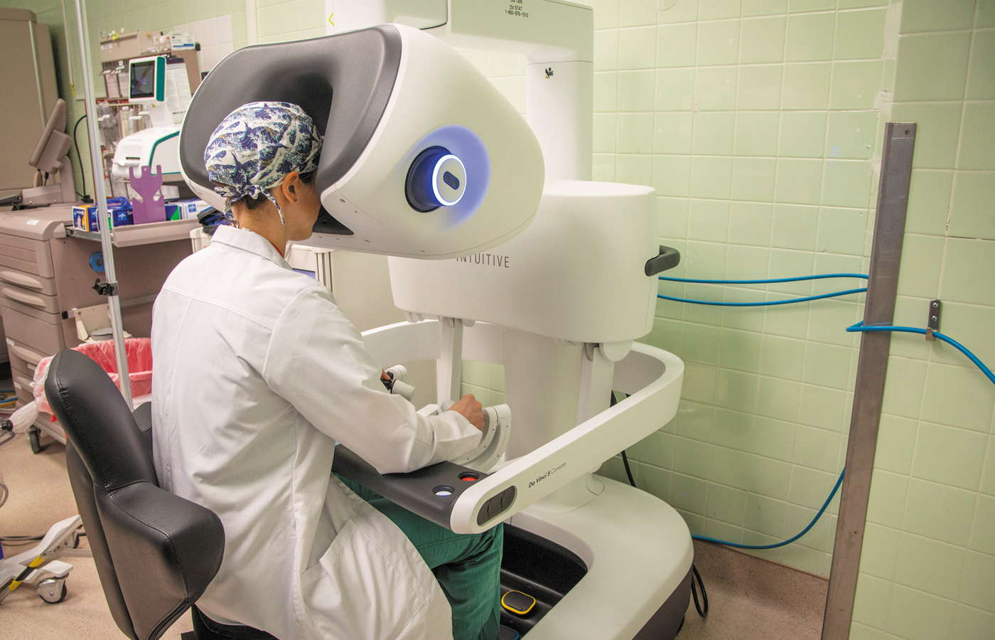 A doctor looking into a robotic surgery machine.